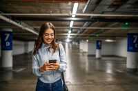 Businesswoman,In,Underground,Garage.,Elegant,Woman,Using,Smartphone,In,Parking