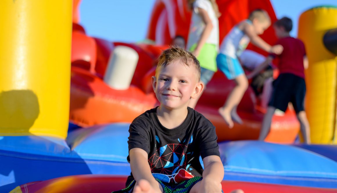 Smiling little boy sitting on a jumping castle