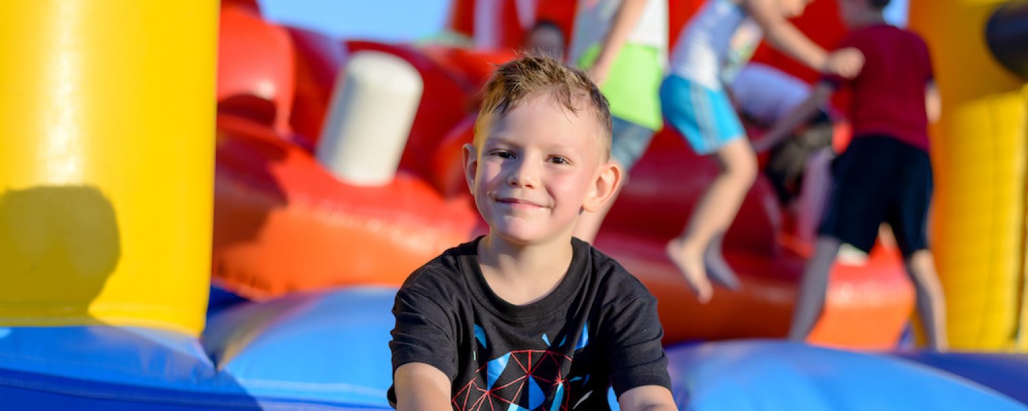 Smiling little boy sitting on a jumping castle