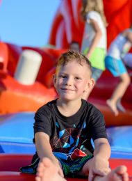 Smiling little boy sitting on a jumping castle